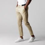 Modelo masculino usando calça casual de algodão com elastano, corte reto, cor bege. Estilo business casual