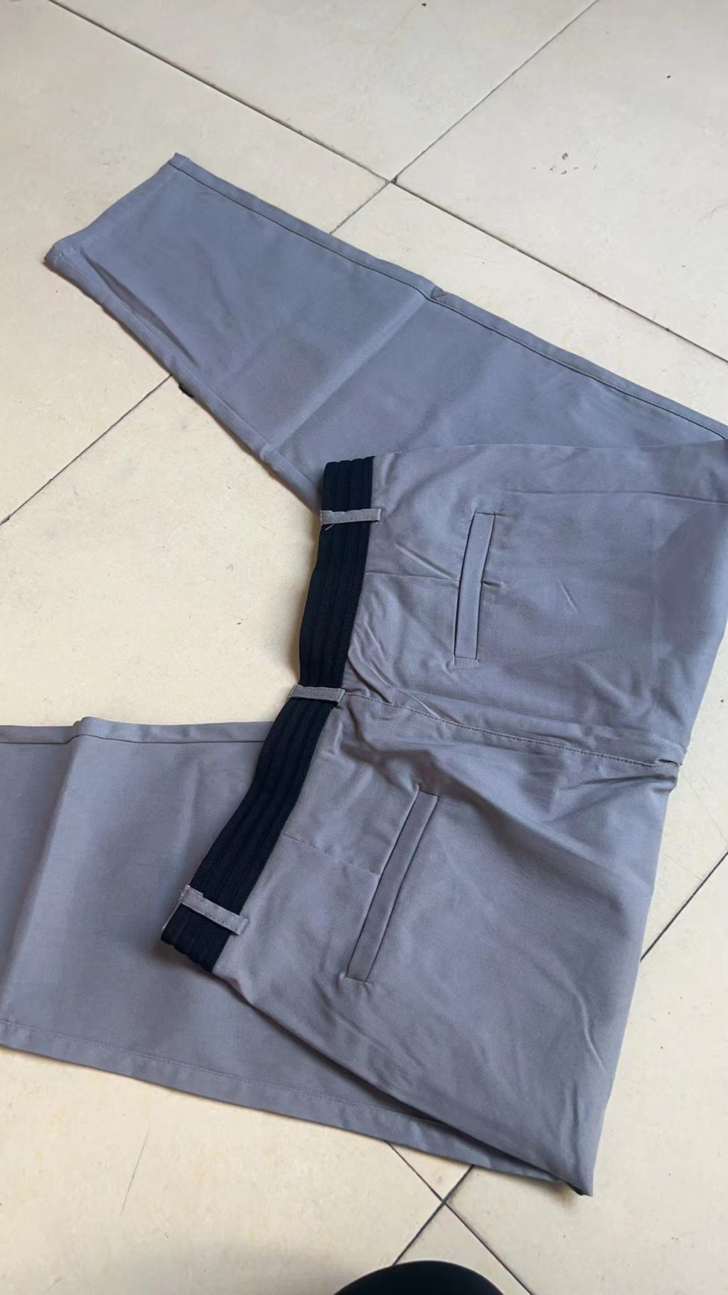 Vista traseira da calça casual masculina de algodão com elastano, corte reto, cor bege. Detalhe do ajuste e costura